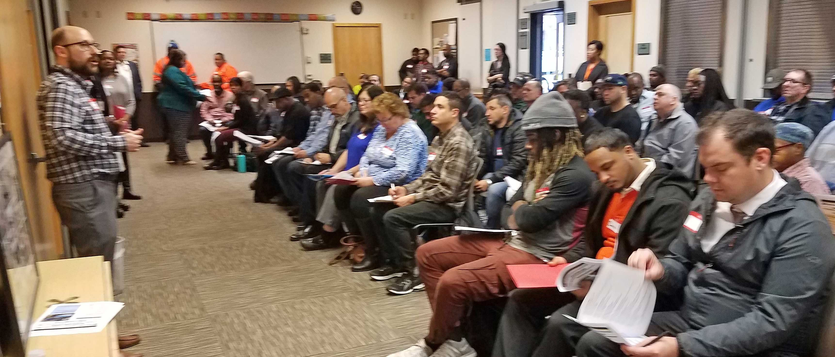 man speaking to roomful of people