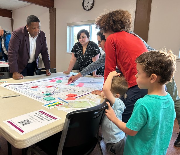 People gathered around a table examining posters in the center