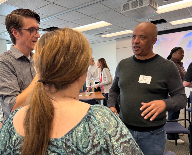 Three people talking in a conference room.