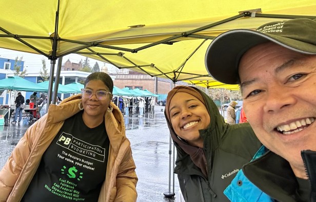 Three county works pose for a photo at an outdoor county event.