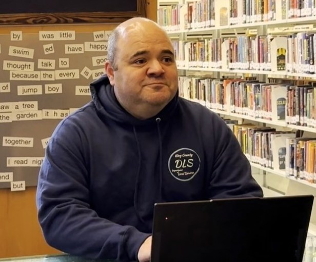 Man sitting behind his laptop at a libary