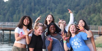 A group of teenagers posing for a picture with trees in the background