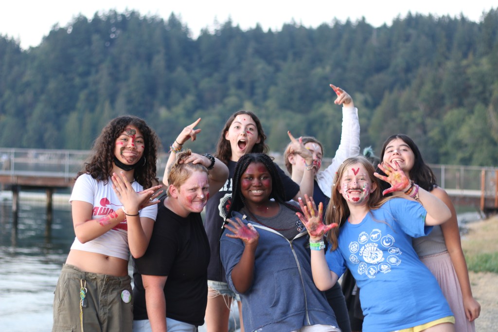 A group of teenagers posing for a picture with trees in the background