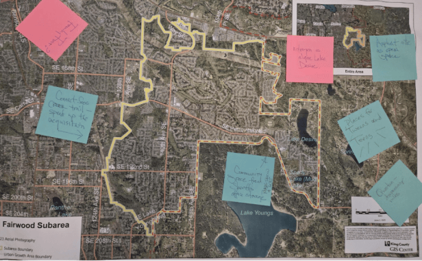 A satellite map of the boundaries of the community of Fairwood in King County, Washington. Outside of the boundary outline are pink and blue sticky notes with writing on them.