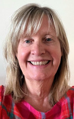 A headshot featuring a woman smiling at the camera.